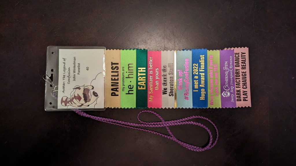 My badge and ribbons from ConFusion 2023